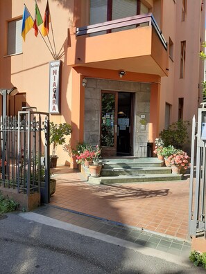 A hotel entrance with a sign reading "Hotel NIGARA," a gated entrance, and potted plants. - Hotel Niagara Rimini (Rimini)