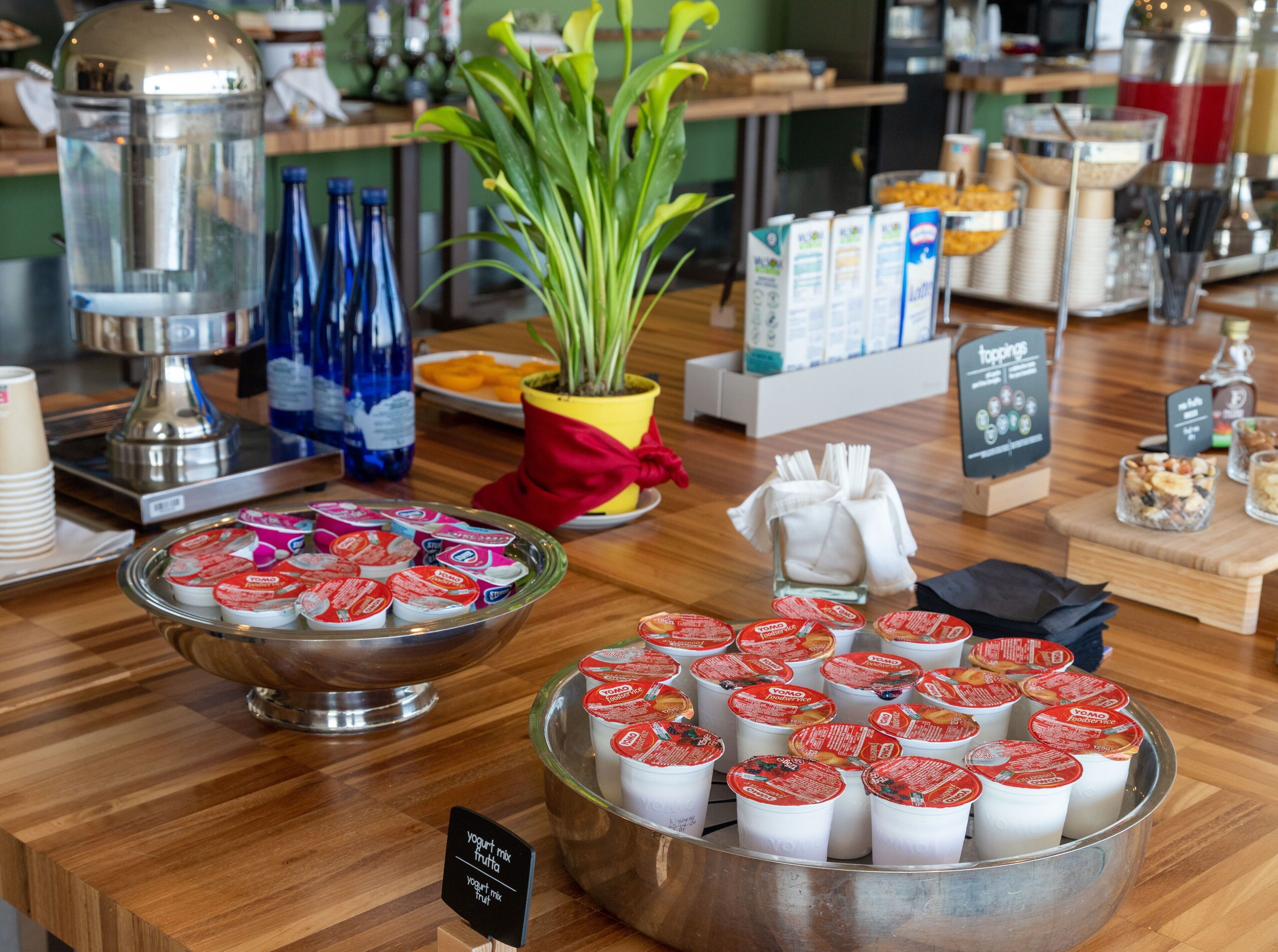 A buffet setup with various food items and a sign indicating 'yogurt mix fruit'.
