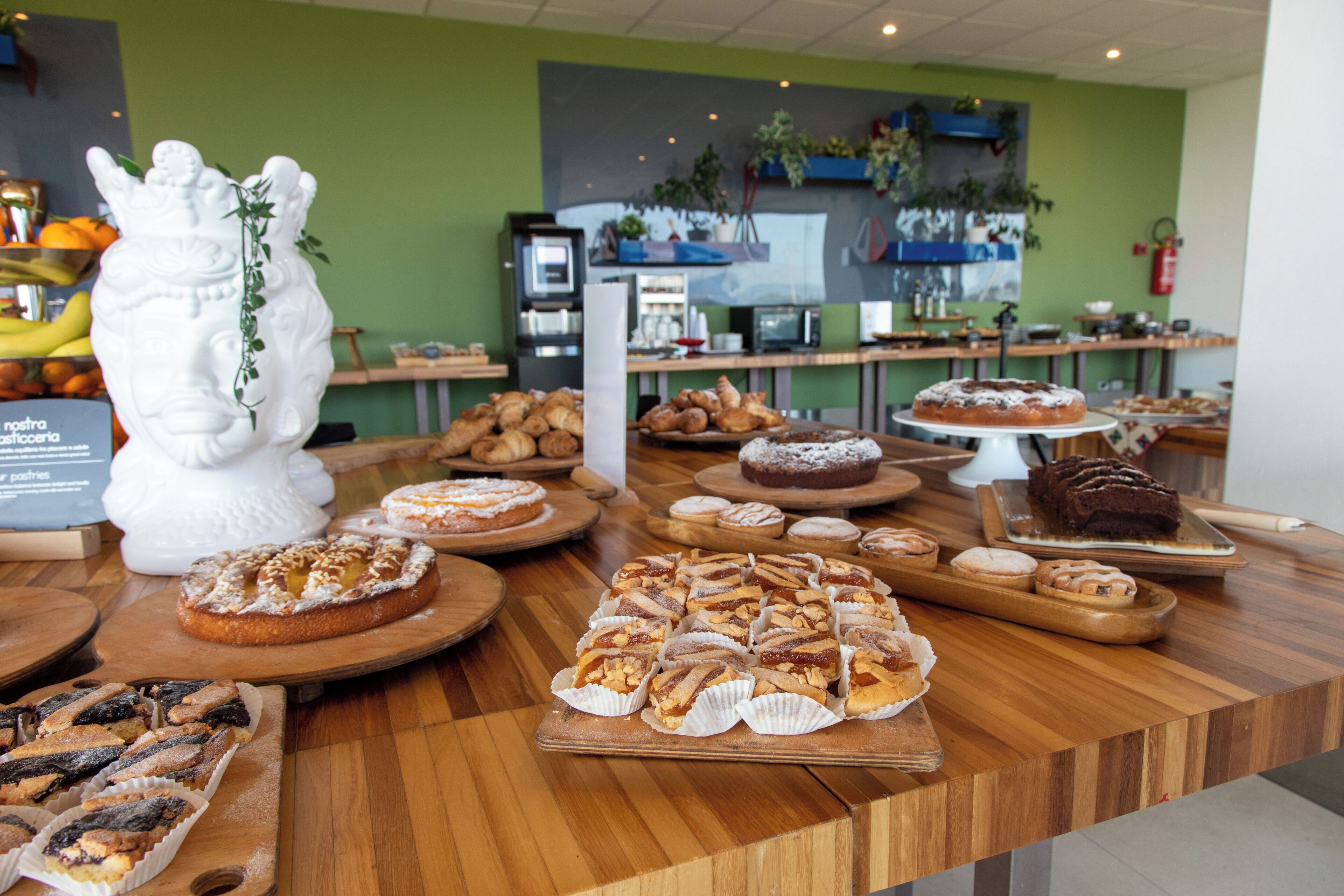 A bakery display with various pastries and a decorative white ceramic figure.