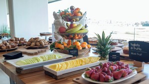 Un bufé con diversas frutas y pasteles.