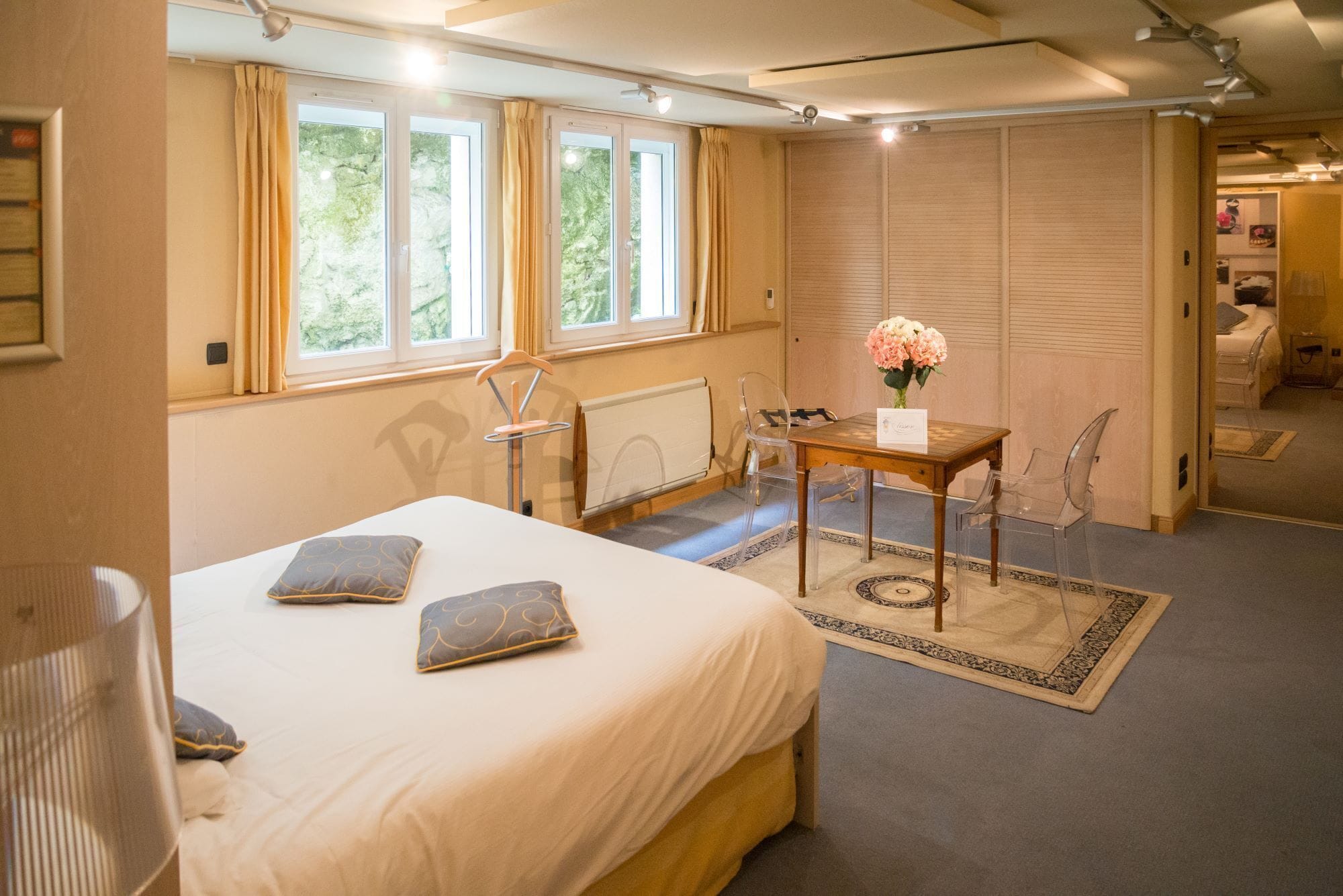 Un dormitorio con cama, una mesa con un florero y una silla.