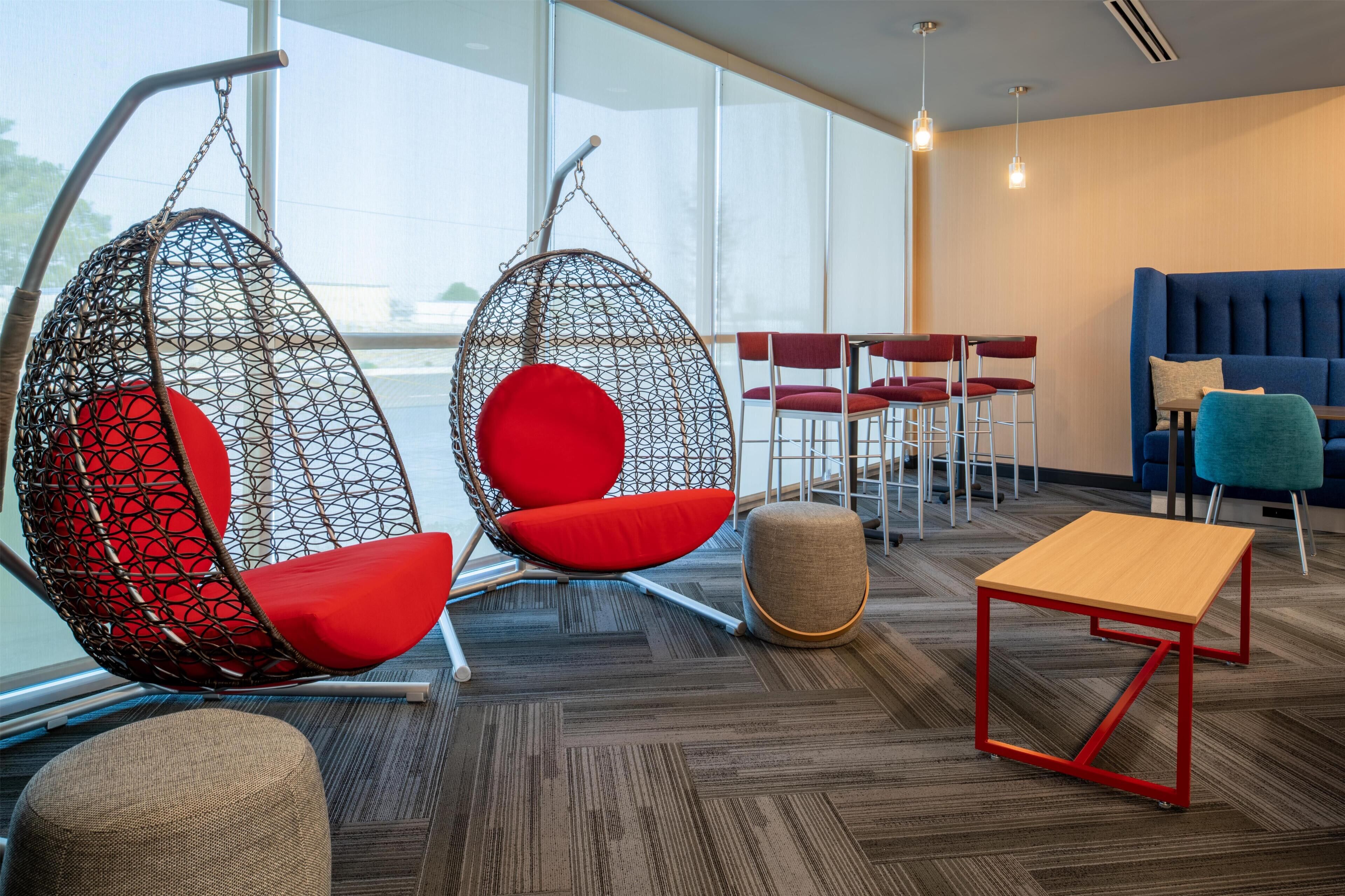 A modern interior with hanging chairs, a blue sofa, and a small wooden table.