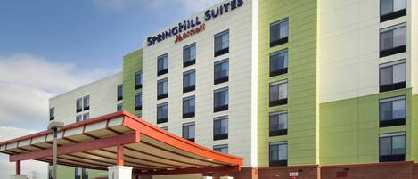 A SpringHill Suites Marriott hotel with a modern design, featuring a covered entrance and multiple floors.