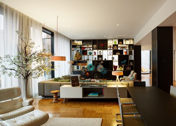 A modern living room with a sofa, coffee table, and a bookshelf filled with decorative items. - citizenM Glasgow (Glasgow)