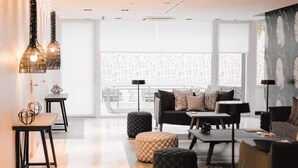 Una sala de estar moderna con sofá, otomanes y lámparas colgantes.