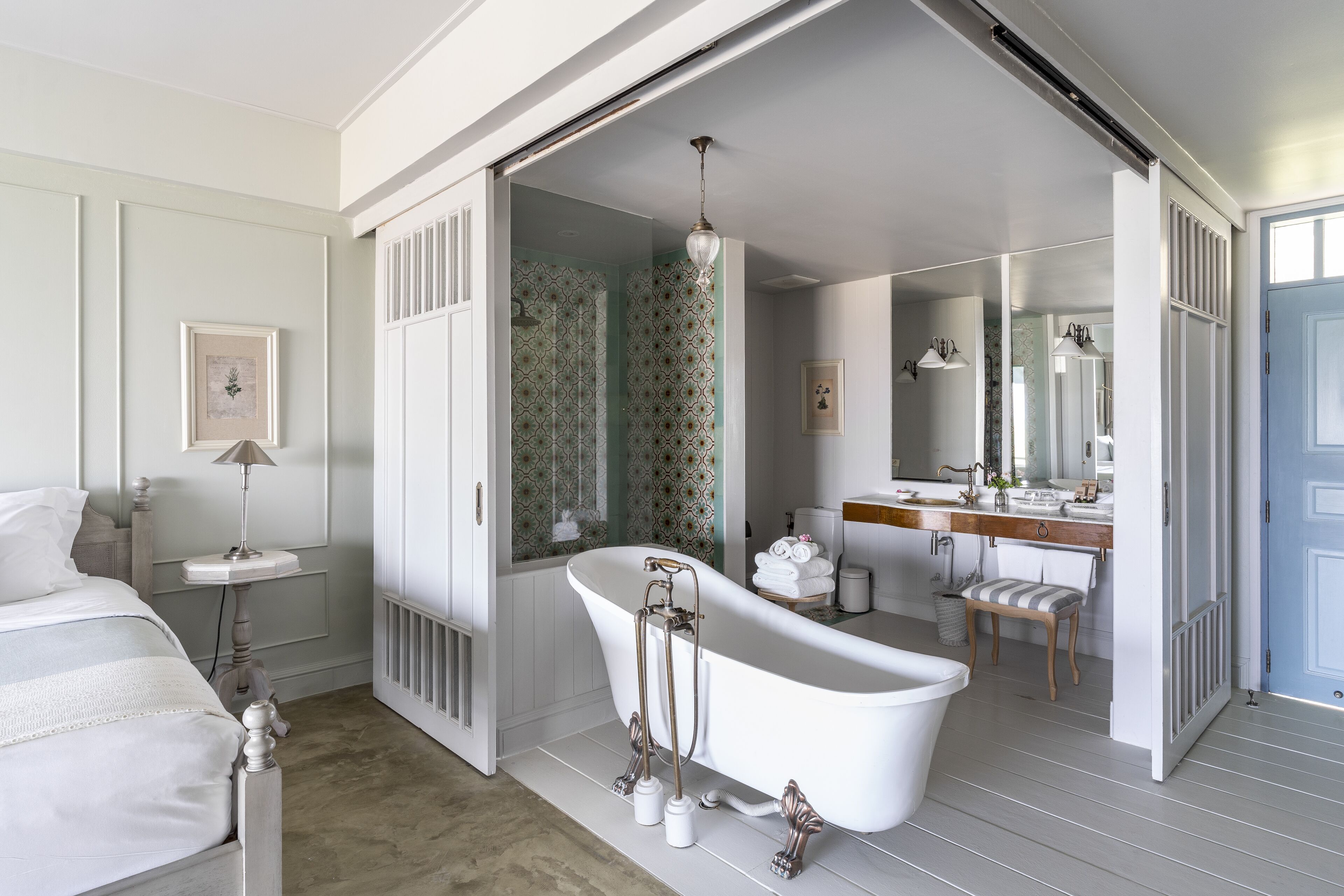 A bathroom with a freestanding bathtub, a vanity with a mirror, and a shower area.
