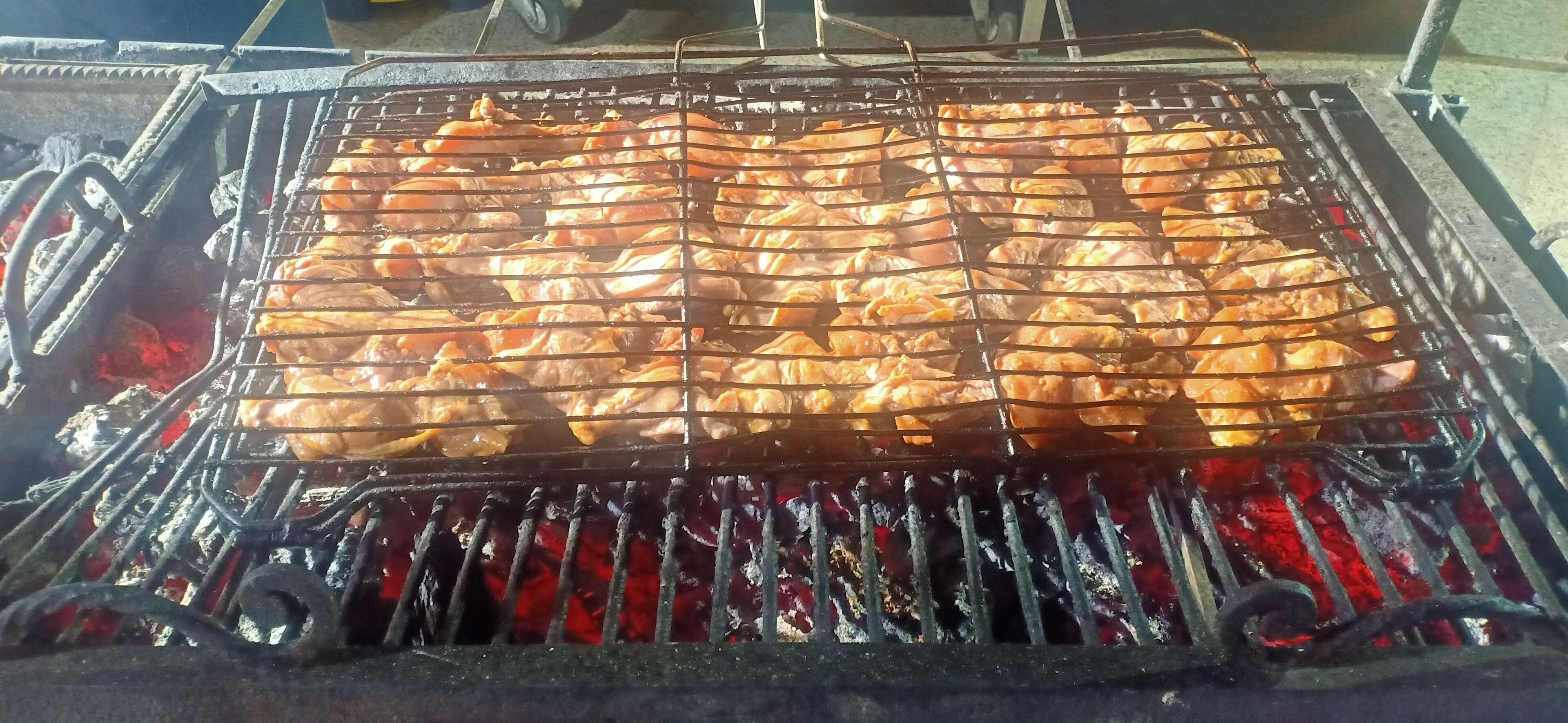 A grill with meat being cooked over charcoal.