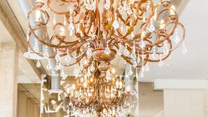 A spacious lobby with a large, ornate chandelier, a plush purple sofa, and a glass coffee table. - The Waterfront hotel & spa by Misty blue hotels (Durban)
