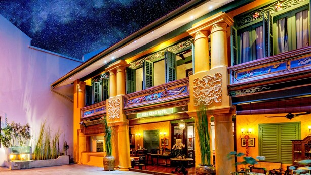 Un hotel de arquitectura tradicional, con columnas ornamentadas y un letrero que dice 'YENG KENG HOTEL'.