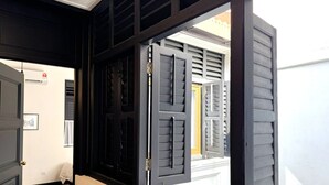 Una habitación con un ventanal grande, una puerta y un pasillo que conduce a otra habitación.