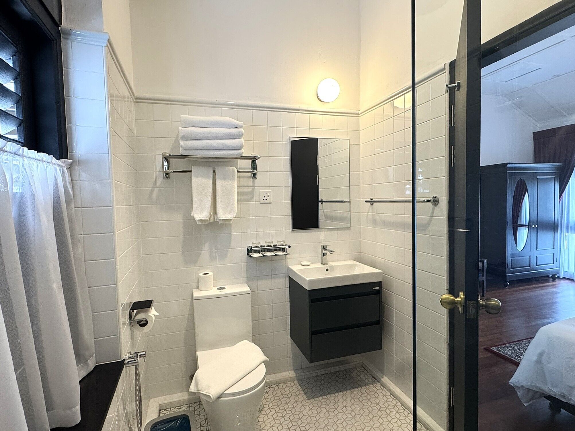 A modern bathroom with a toilet, sink, and a glass shower enclosure.