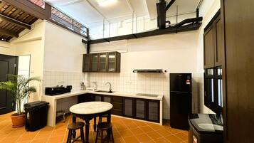 Kompakti keittiö, jossa on keskeinen saareke, jääkaappi ja mikroaaltouuni.
