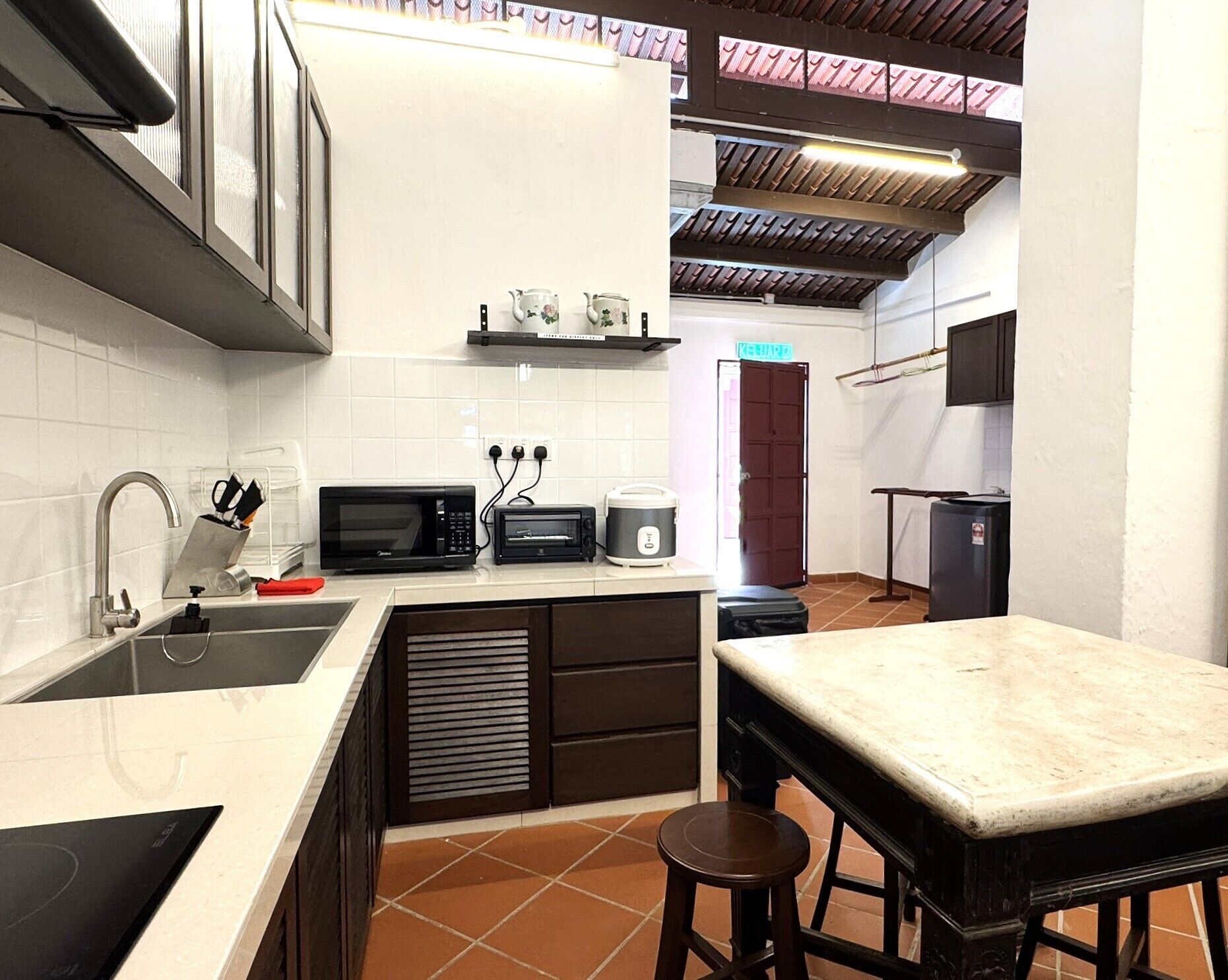 A compact kitchen with a sink, microwave, toaster, and a small countertop.