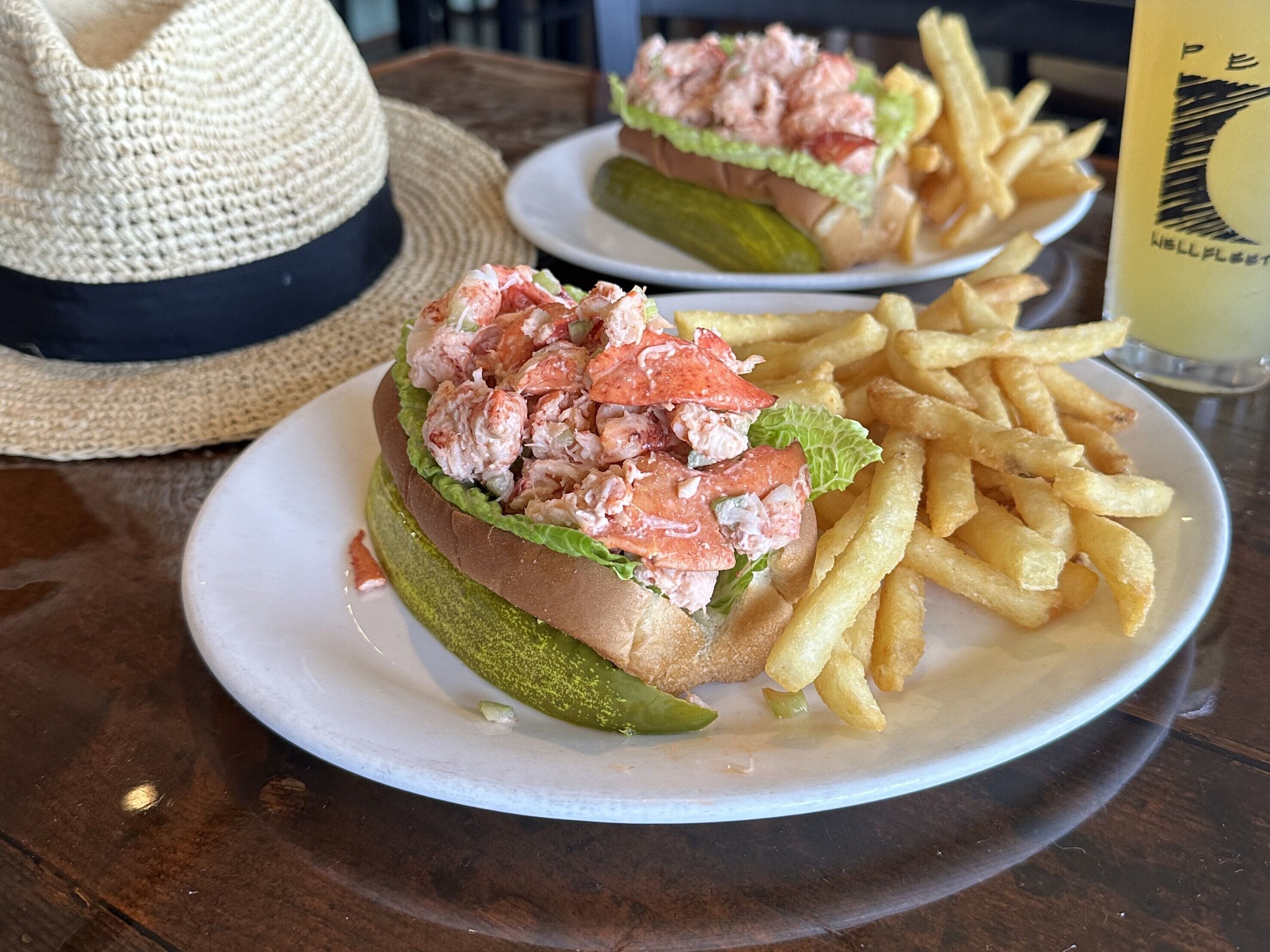 Une assiette avec un sandwich au homard et des frites.