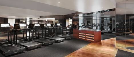 A modern gym with treadmills, exercise equipment, and a reception desk.