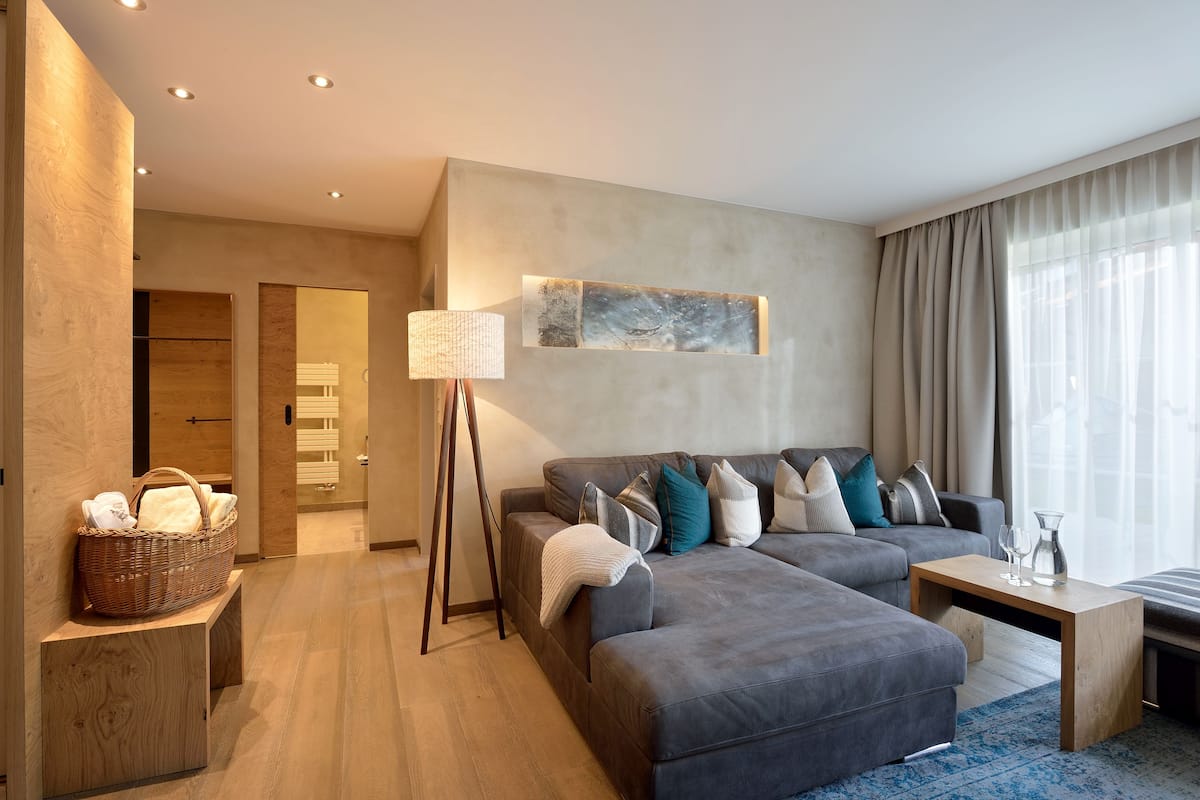A modern living room with a grey sofa, a wooden coffee table, and a standing lamp.