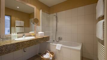 A modern bathroom with a granite countertop, a sink, a bathtub, and a shower.