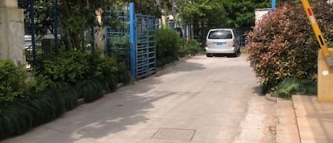 A gated driveway leading to a parked vehicle.