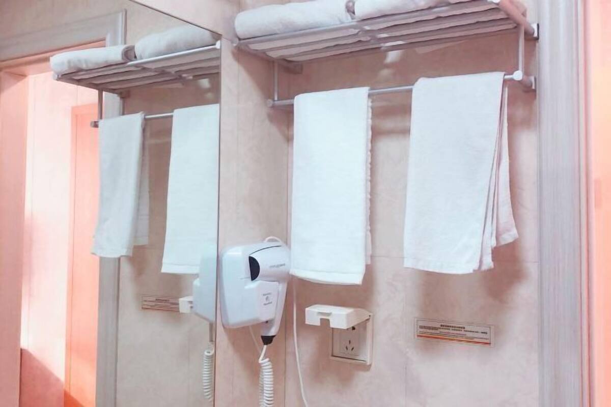 Un baño con secador de pelo, toallas y toma de corriente.