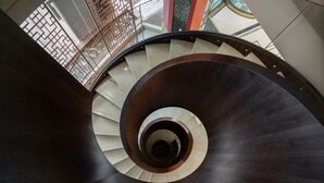 A spiral staircase with a dark wooden finish and beige steps. - Minshan Lhasa Grand Hotel (Chengdu)