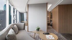 A modern hotel room with a sofa, a small table, and a potted plant. - Minshan Lhasa Grand Hotel (Chengdu)