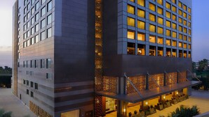 Un moderno hotel Hilton con una entrada destacada, varios pisos y una fachada bien iluminada.