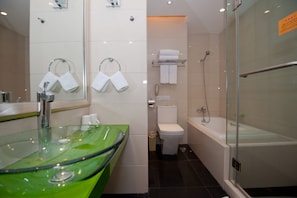 A modern bathroom with a glass sink, a toilet, a bathtub, and a shower.