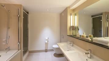 A modern bathroom with a glass-enclosed shower, a white toilet, and a large vanity with a mirror.