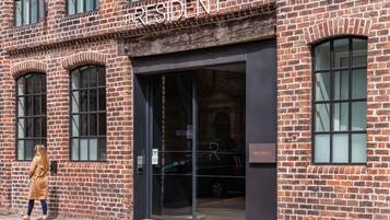 A brick building with the sign "RESIDENT" above the entrance.