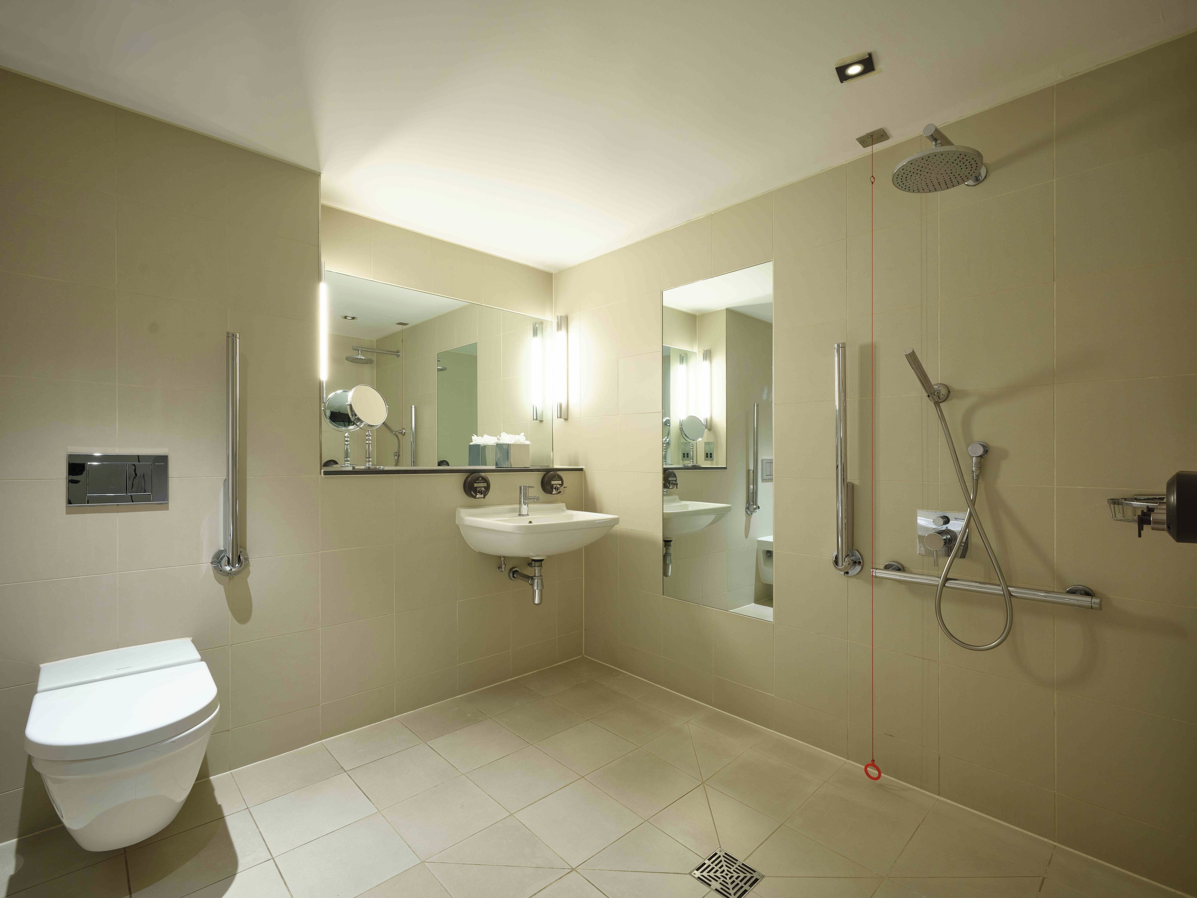 A modern bathroom with a toilet, sink, and shower.