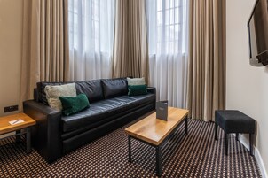Suite junior, varias camas | Zona de estar | Televisión LCD de 32 pulgadas con canales digitales, una televisión