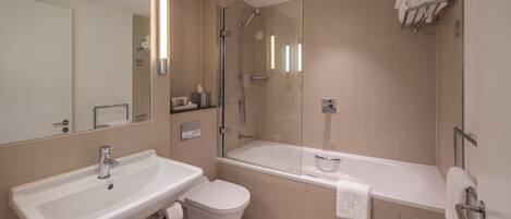 A modern bathroom with a sink, toilet, and bathtub.