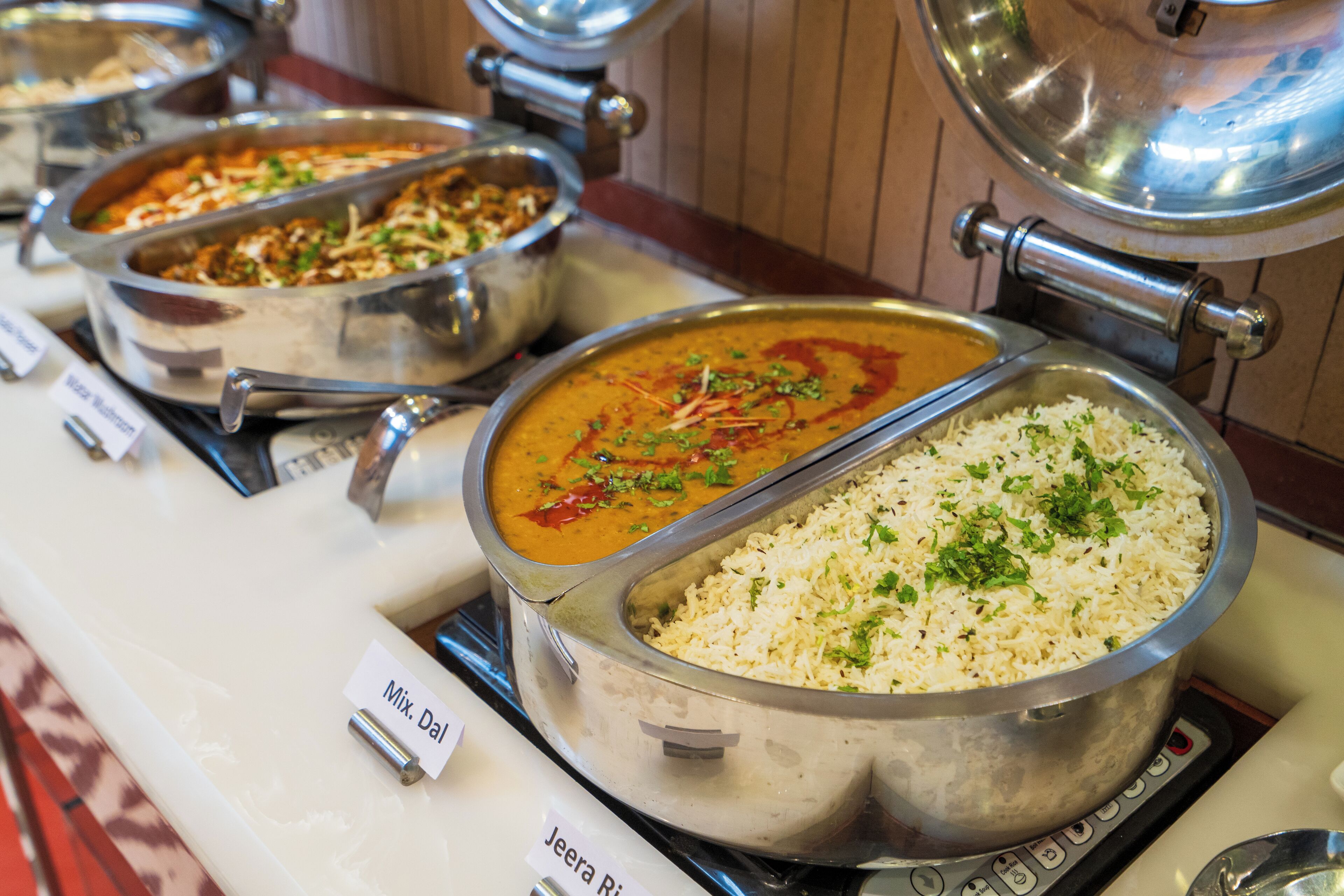 Een buffet met diverse gerechten, waaronder rijst en roerbakgerechten.