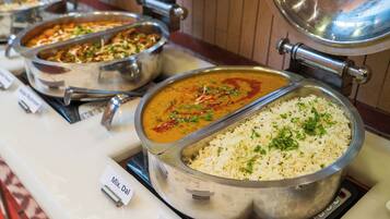 Een buffet met diverse gerechten, waaronder rijst en roerbakgerechten.