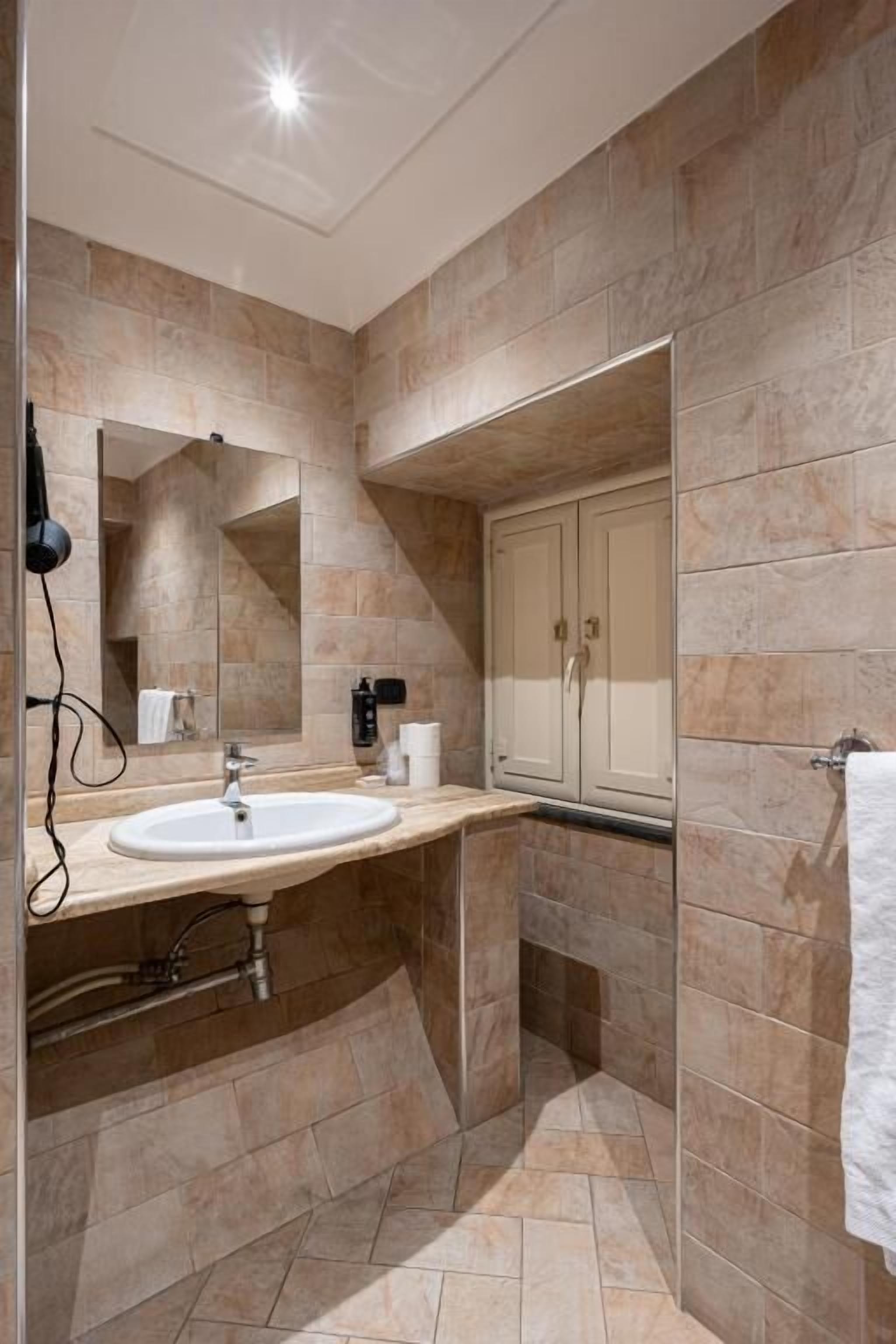 Un bany modern amb un lavabo gran, mirall i armari.