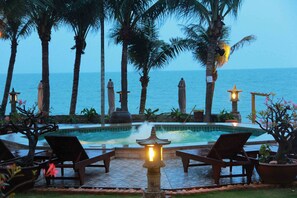 A pool area with lounge chairs and a view of the ocean. - Novela Muine Resort & Spa (Mui Ne)