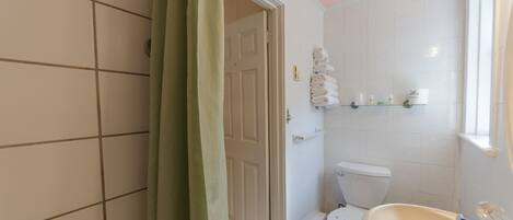 A bathroom with a toilet, sink, and shower curtain.
