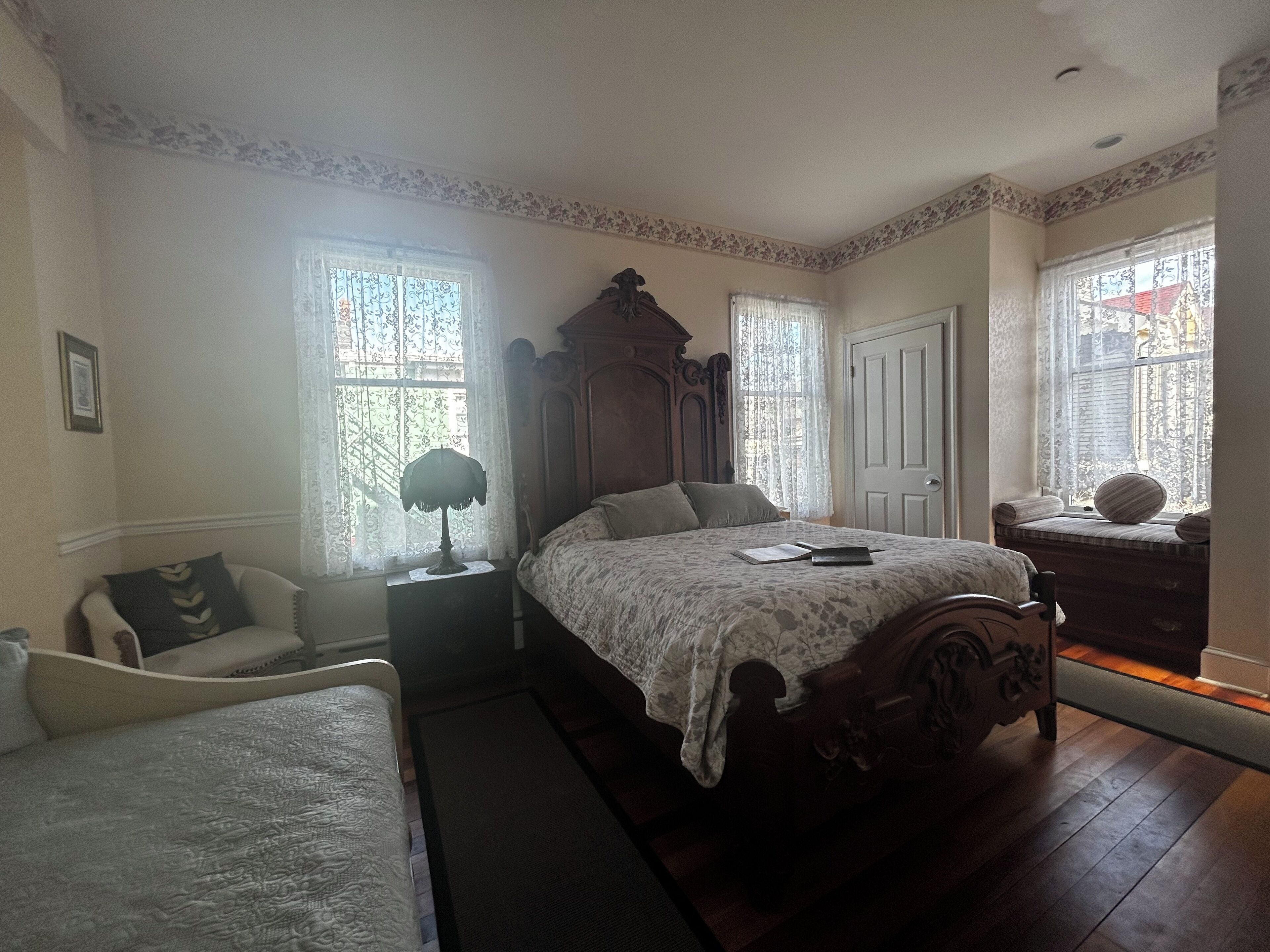 Une chambre à coucher avec un grand lit, une table de chevet, une chaise et une commode.