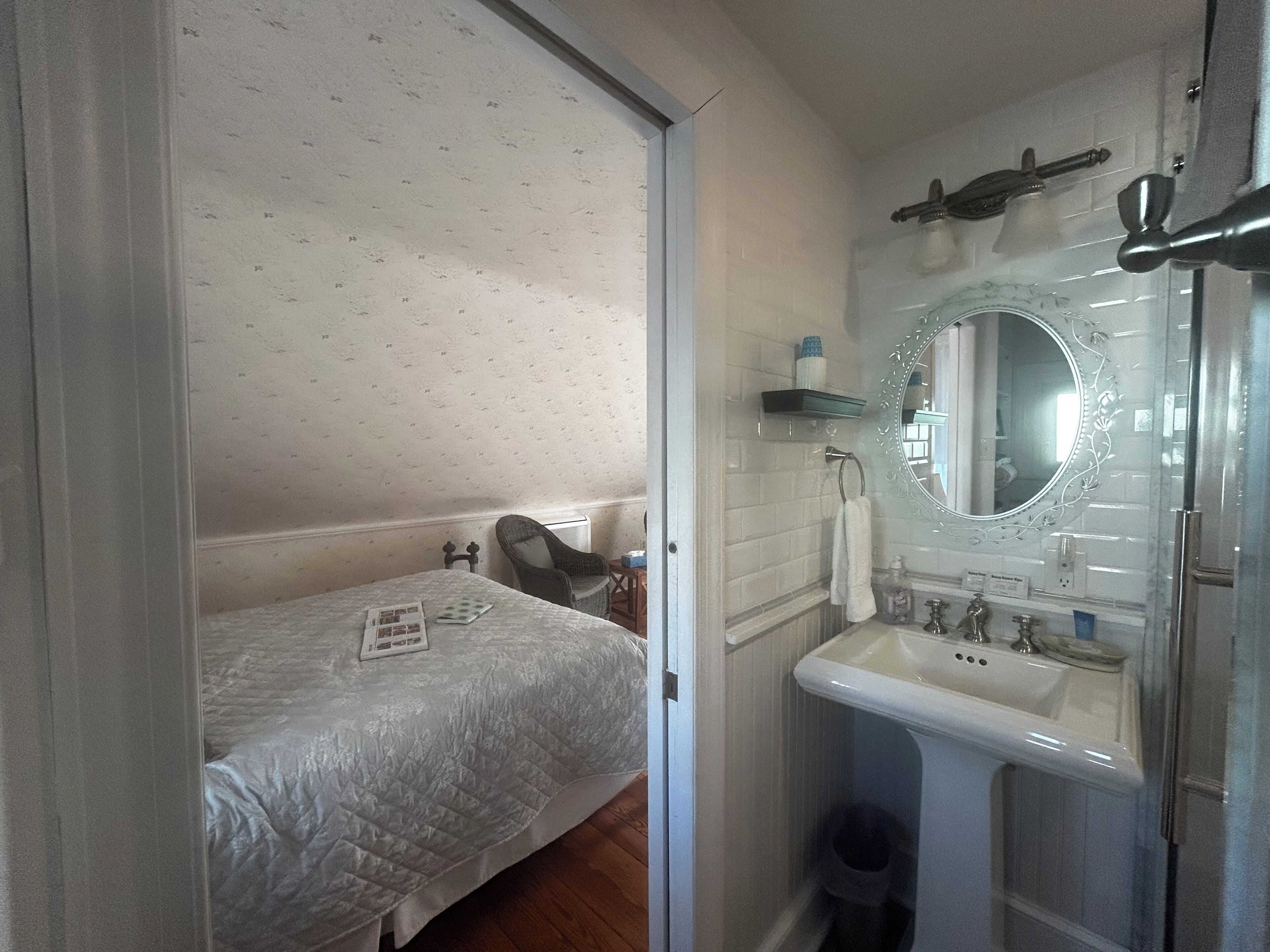 Ein kleines, gemütliches Schlafzimmer mit einem Einzelbett, einem Sessel und einem Nachttisch.