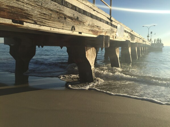 Un muelle se extiende sobre el agua, con olas rompiendo contra él.
