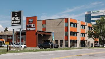 Un hotel con un cartel que indica que es el "HOTEL DE DAUPHIN" y un letrero de "PARKING 20".