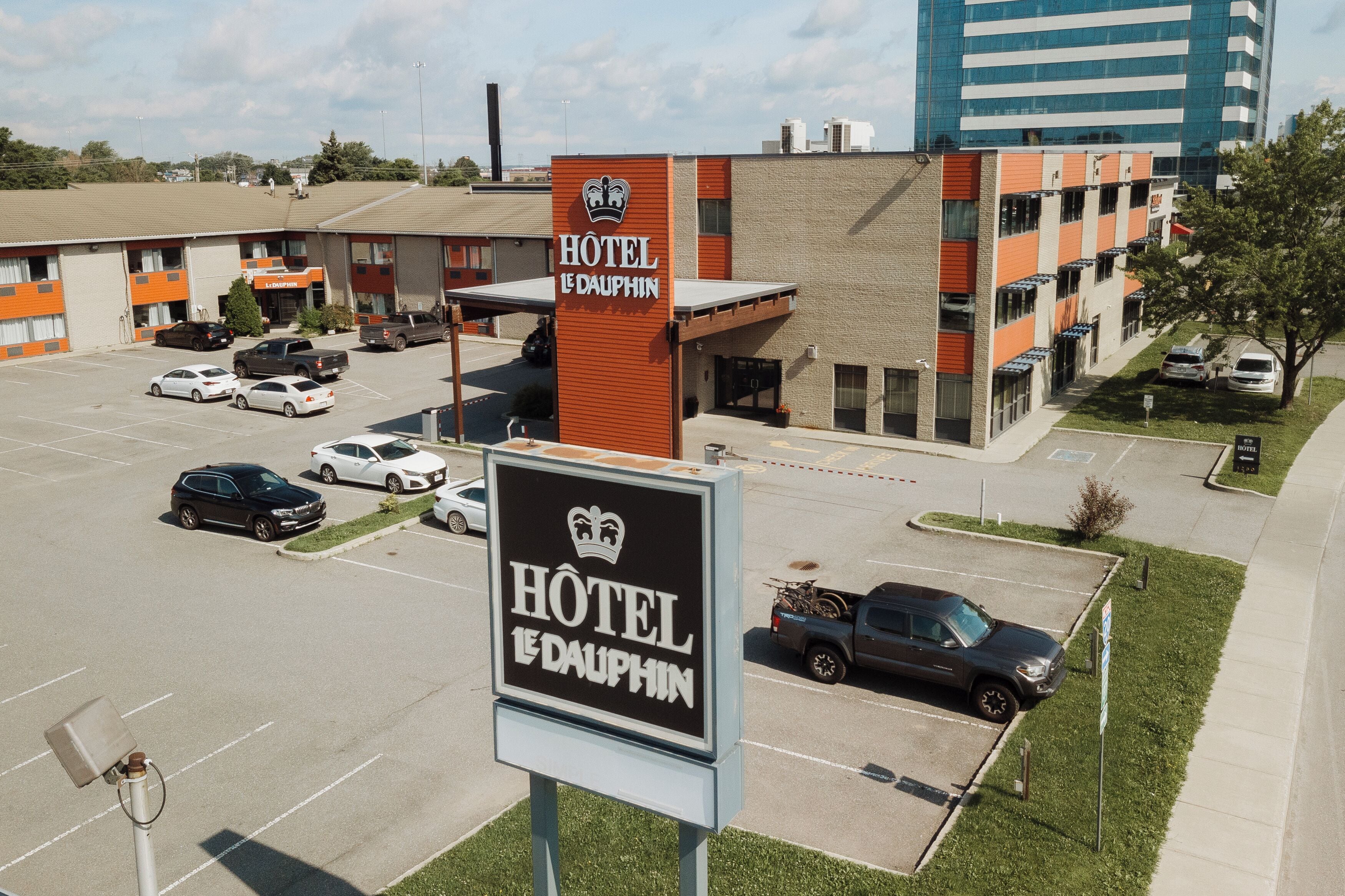 A hotel sign with a crown logo and the name "HOTEL LE DAUPHIN".