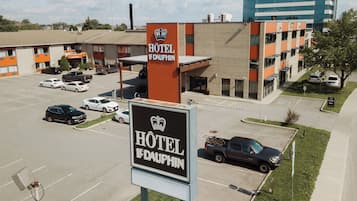 A hotel sign with a crown logo and the name "HOTEL LE DAUPHIN".