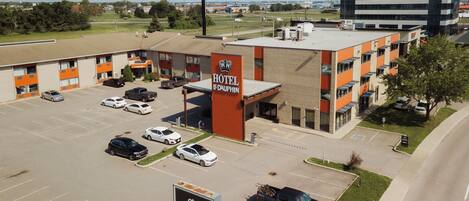 Un hotel con estacionamiento, varias edificaciones y un complejo de oficinas grande al fondo.