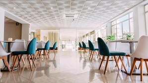 A spacious, well-lit dining area with modern chairs and tables, large windows, and a clean, tiled floor. - Hotel Safari (Gandia)