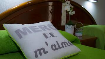 Una cama con un edredón verde y una almohada que dice "MERCO DE M'AMO".