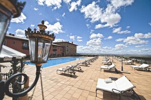 Una piscina al aire libre, sillones reclinables de piscina