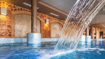 Relax by the serene indoor pool, featuring a gentle waterfall and modern lighting.