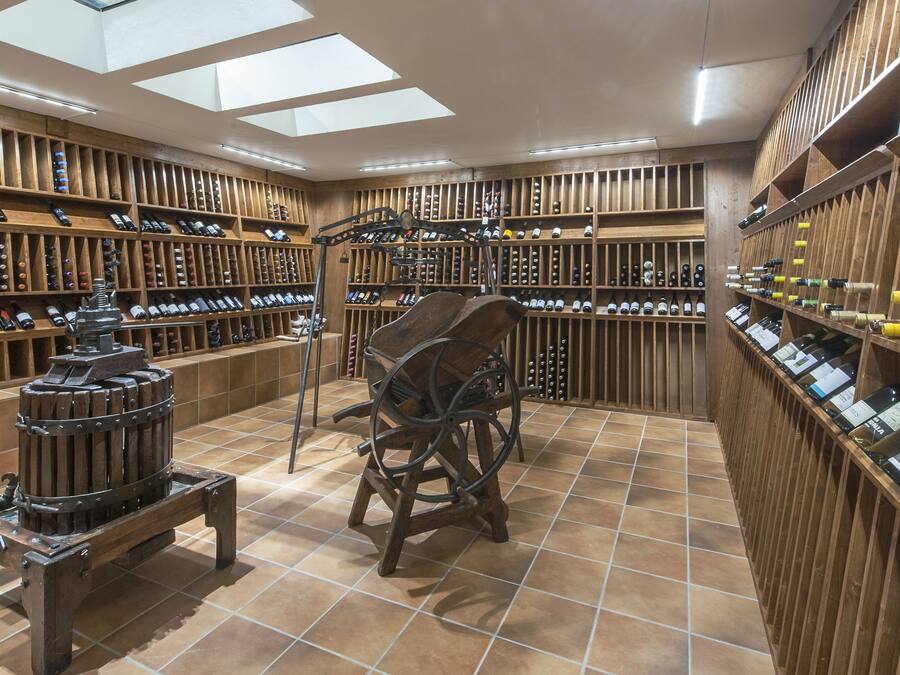 A wine cellar with wooden shelves and a wine rack.