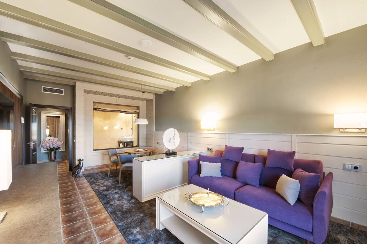 Una sala de estar moderna con un sofá, una mesita de centro y una cocina al fondo.